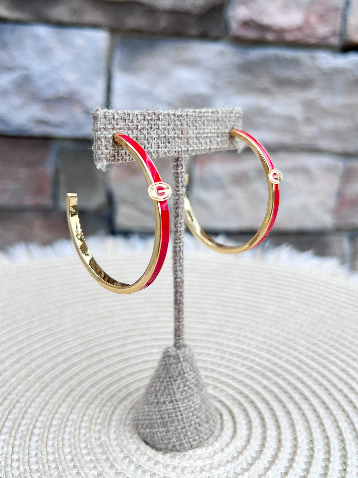 Gold hoop earrings with red enamel detailing and the Georgia Bulldogs "G" logo.