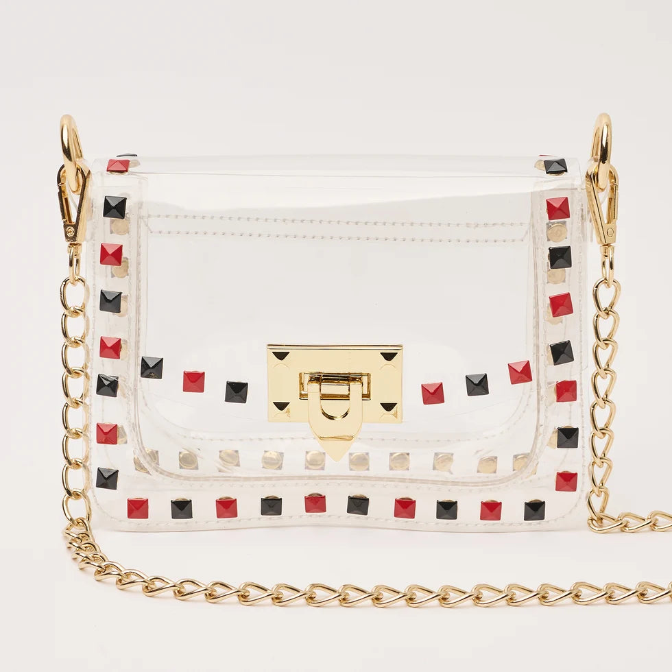 The Jackie Clear Stadium Bag with black and red studs and a gold chain strap