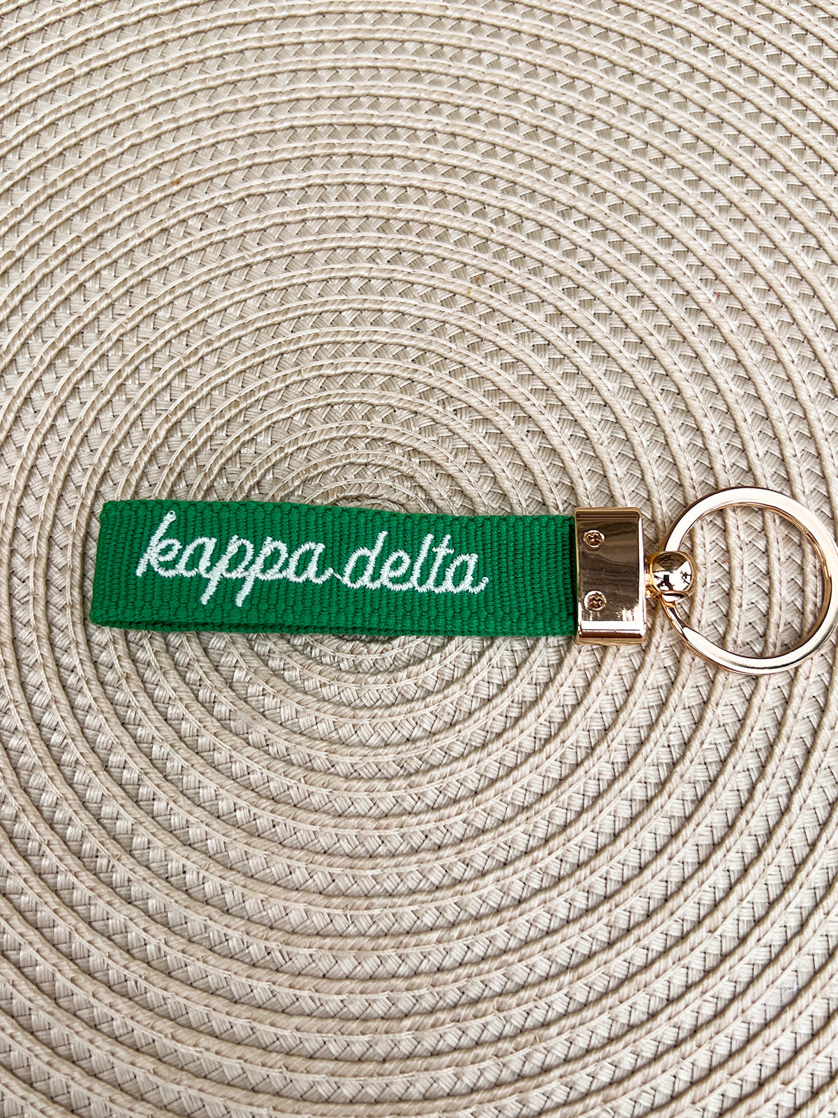Double-sided embroidered Kappa Delta sorority keychain with white Greek letters, script sorority name, and gold hardware.