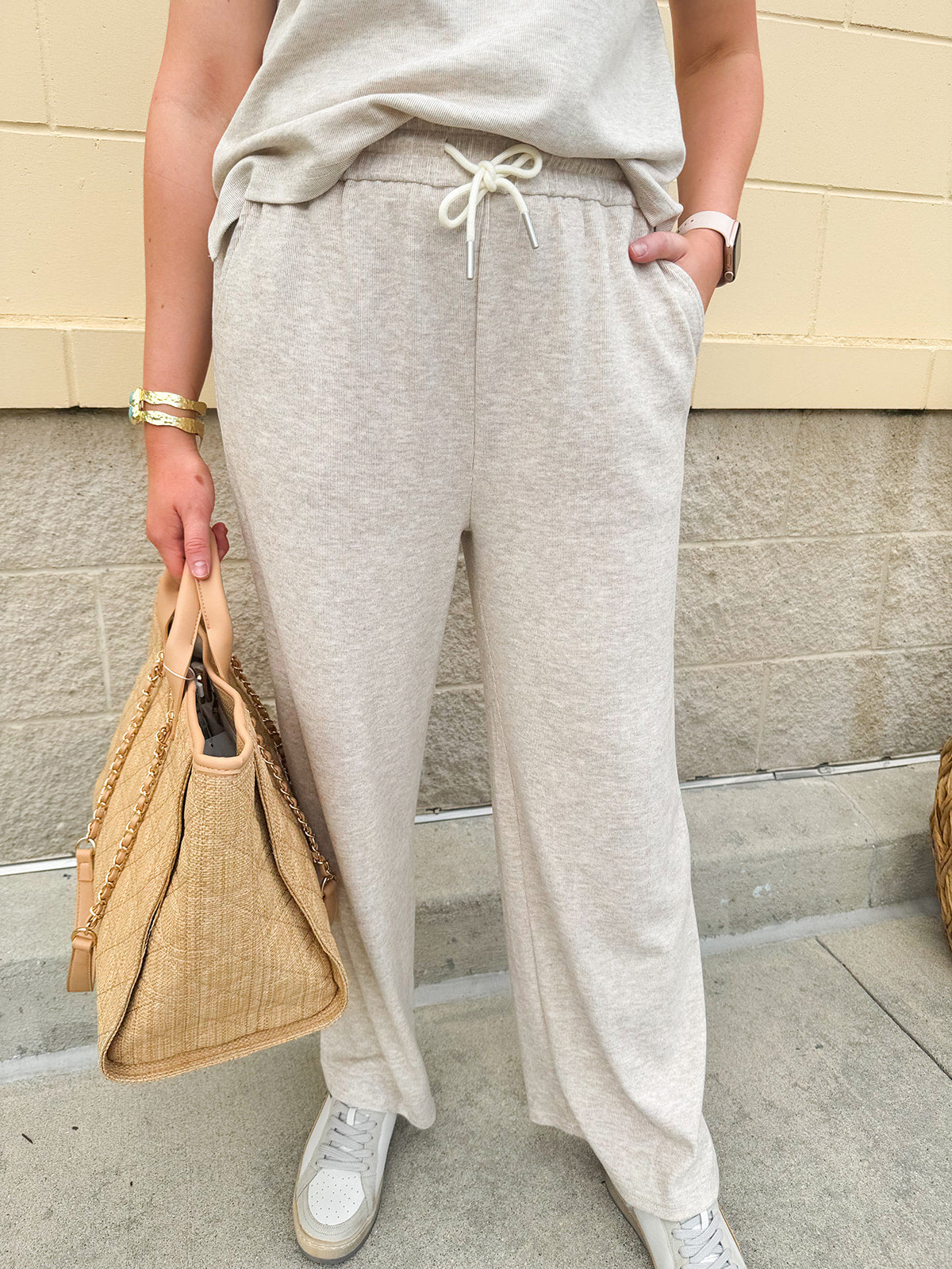 Taupe knit pants with elastic waistband and side pockets, styled with a casual top for a relaxed everyday look.