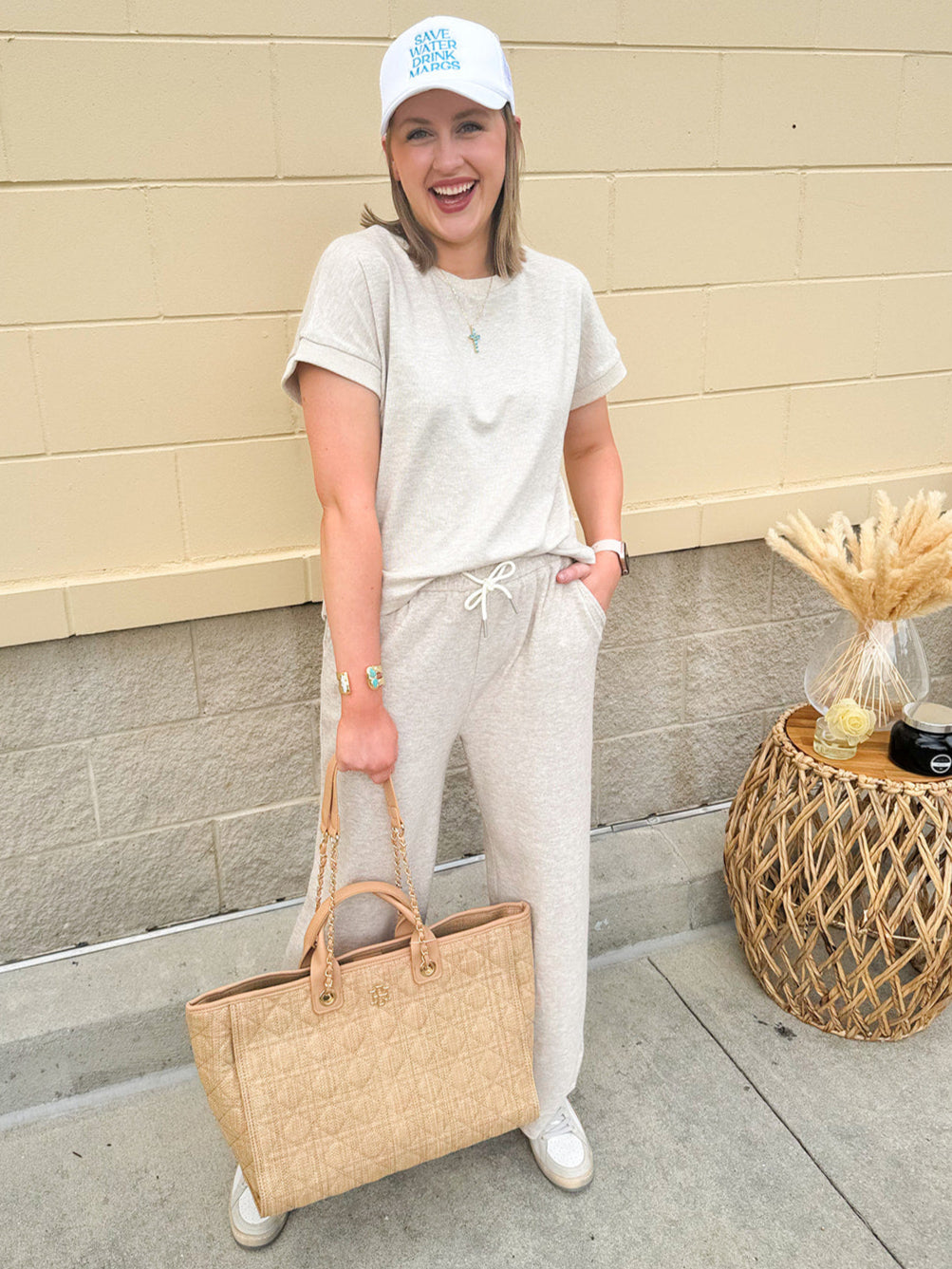 Taupe short sleeve knit top with ribbed collar and cuffed sleeves, styled casually with matching knit pants.