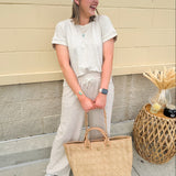 Taupe short sleeve knit top with ribbed collar and cuffed sleeves, styled casually with matching knit pants.
