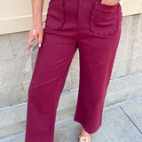Burgundy straight-leg ankle pants with scalloped front pockets and a structured woven fabric with a denim-inspired finish.