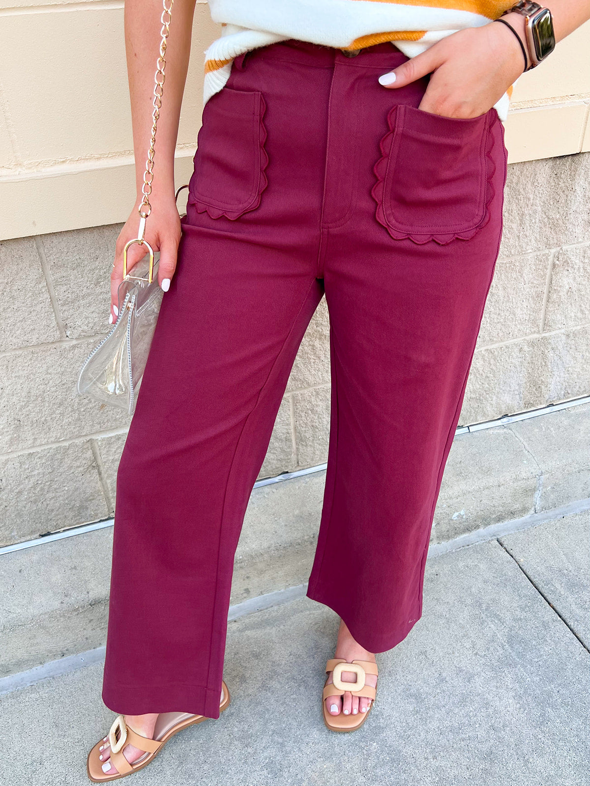Burgundy straight-leg ankle pants with scalloped front pockets and a structured woven fabric with a denim-inspired finish.