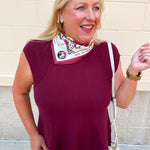 Garnet sleeveless top with ribbed shoulder panels, stitched texture detailing, and a smooth structured body.