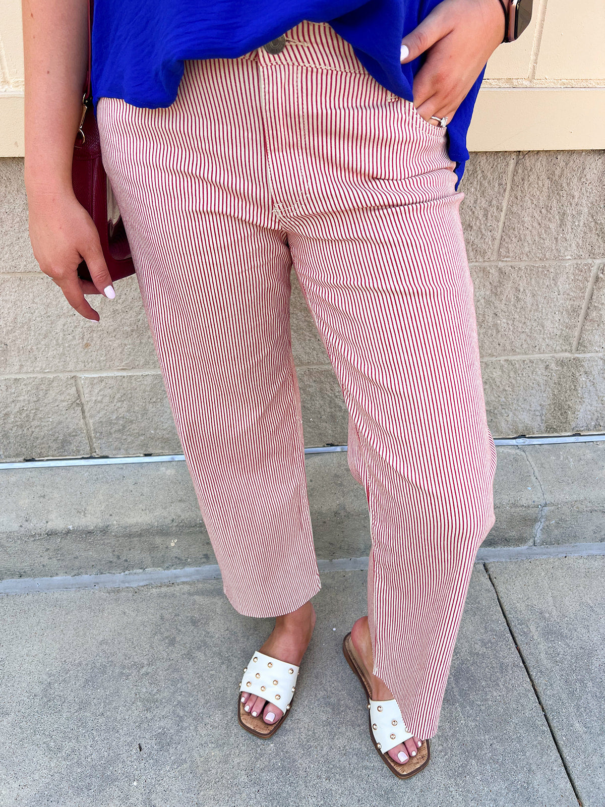High-rise red and ivory striped wide straight leg pants with a structured twill fabric and raw hem.