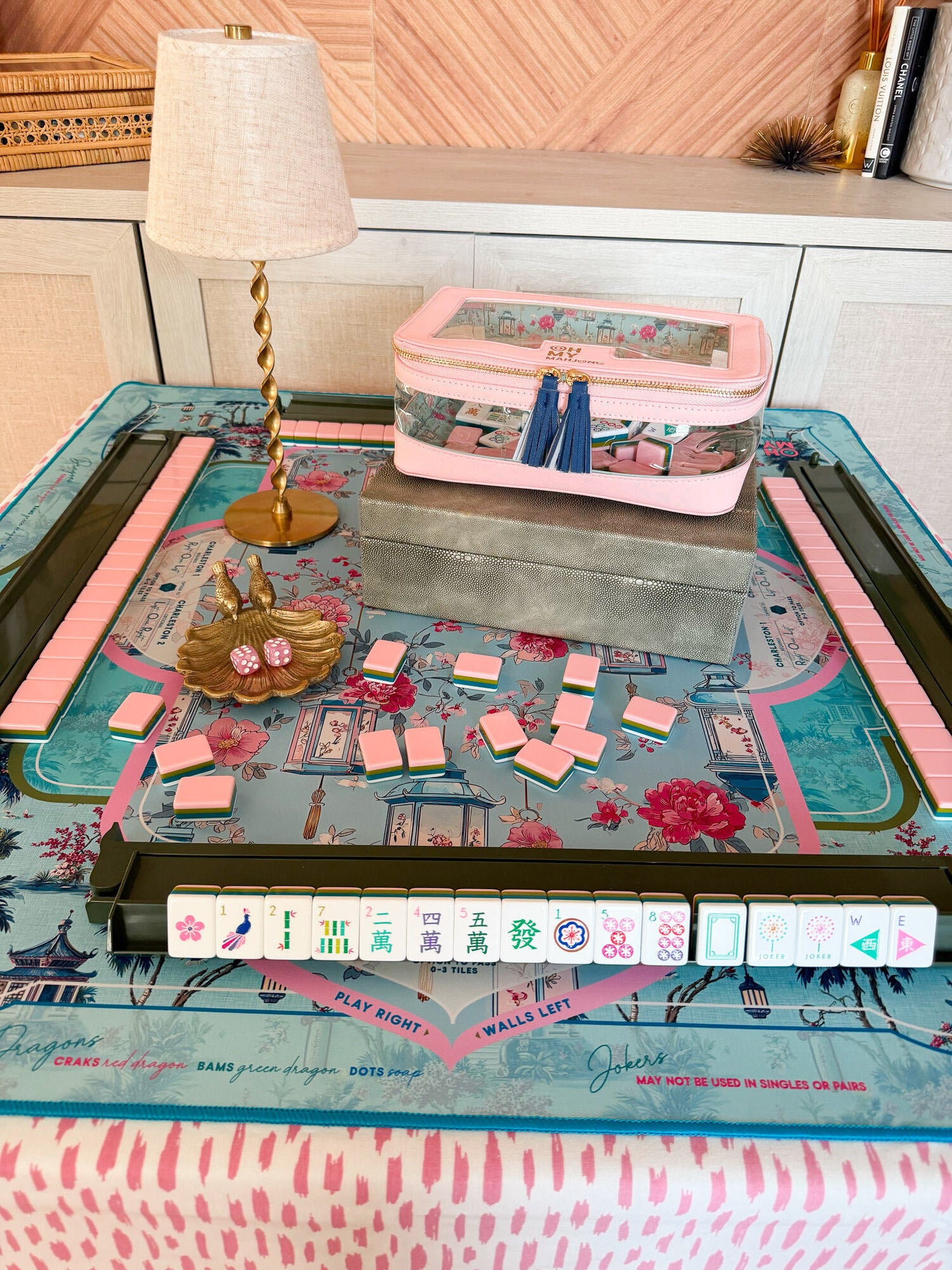 La Fête x Radiance luxury mahjong tablescape with La Fête tiles, Radiance mat, Matcha green racks, light pink tile storage bag, Blush Empress dice, gold songbird dice catchall and Aurelia rechargeable lamp