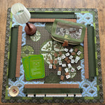 Mabel x Verdant Moss luxury Mahjong tablescape featuring olive green, blue, and brown tones with Mabel Mahjong tiles, Verdant Moss mat, Matcha Green racks, olive accessories, Maribel beaded lamp, Garden Perch dice dish, and Empress Tortoise dice.