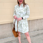 White floral mini dress with green print, classic collar, button front, and removable belt