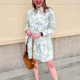 White floral mini dress with green print, classic collar, button front, and removable belt