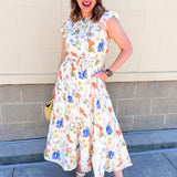 white maxi dress with blue and orange floral detail and tie-waist