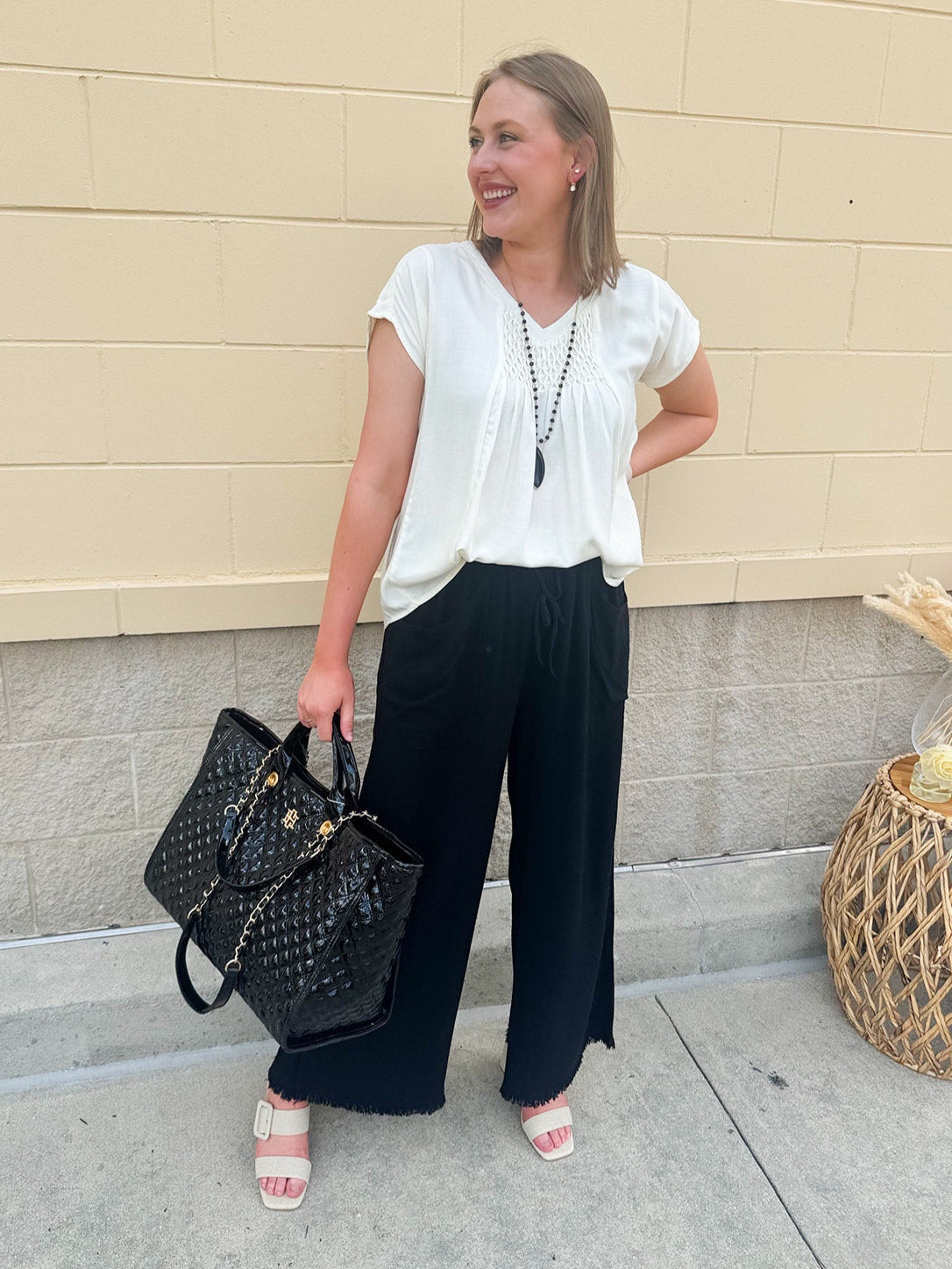 Oversized black patent vegan leather tote with braided straps and roomy interior—ideal for daily wear, travel, or laptop carry.