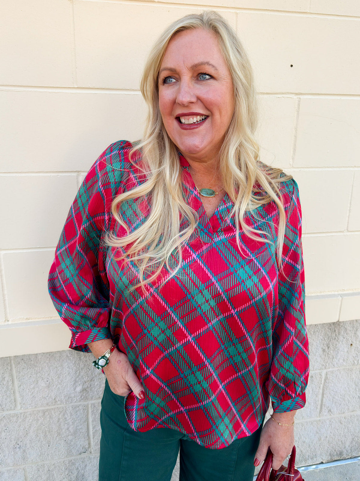 Pink, red, and green plaid top with ruffle neckline and three-quarter puff sleeves with cuffs.