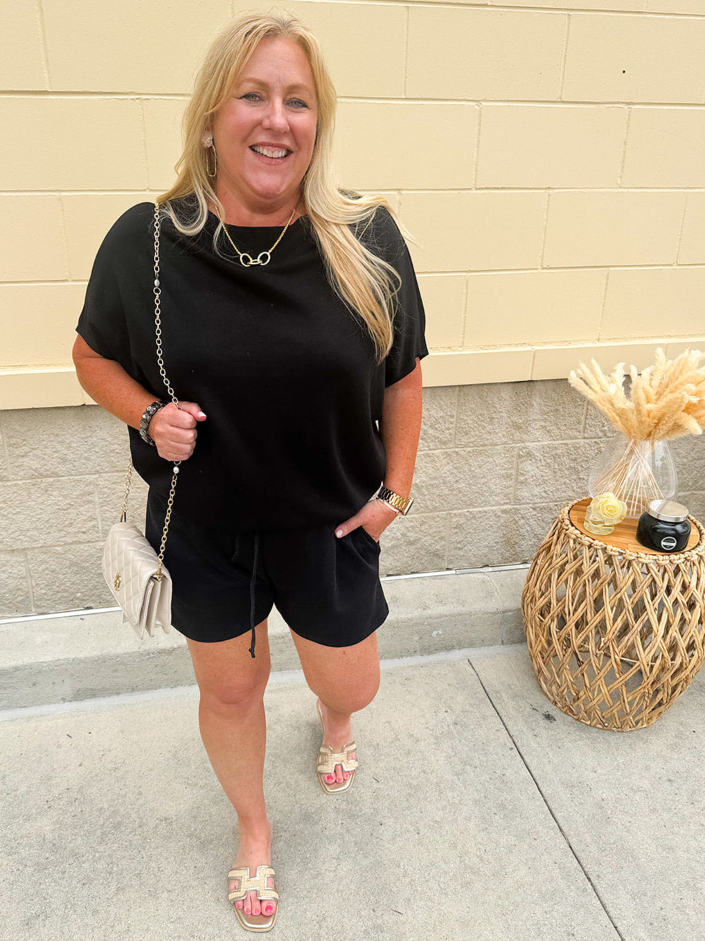 Solid black lounge set with U-neck dolman sleeve top and drawstring shorts, styled for cozy-casual wear.