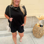 Solid black lounge set with U-neck dolman sleeve top and drawstring shorts, styled for cozy-casual wear.