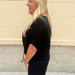 Solid black lounge set with U-neck dolman sleeve top and drawstring shorts, styled for cozy-casual wear.