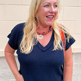 Navy blue short sleeve knit V-neck top with a relaxed fit and lightweight sweater knit fabric.