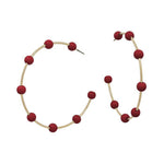 Gold hoop earrings with maroon-coated metal bead accents, offering a bold yet elegant pop of color.
