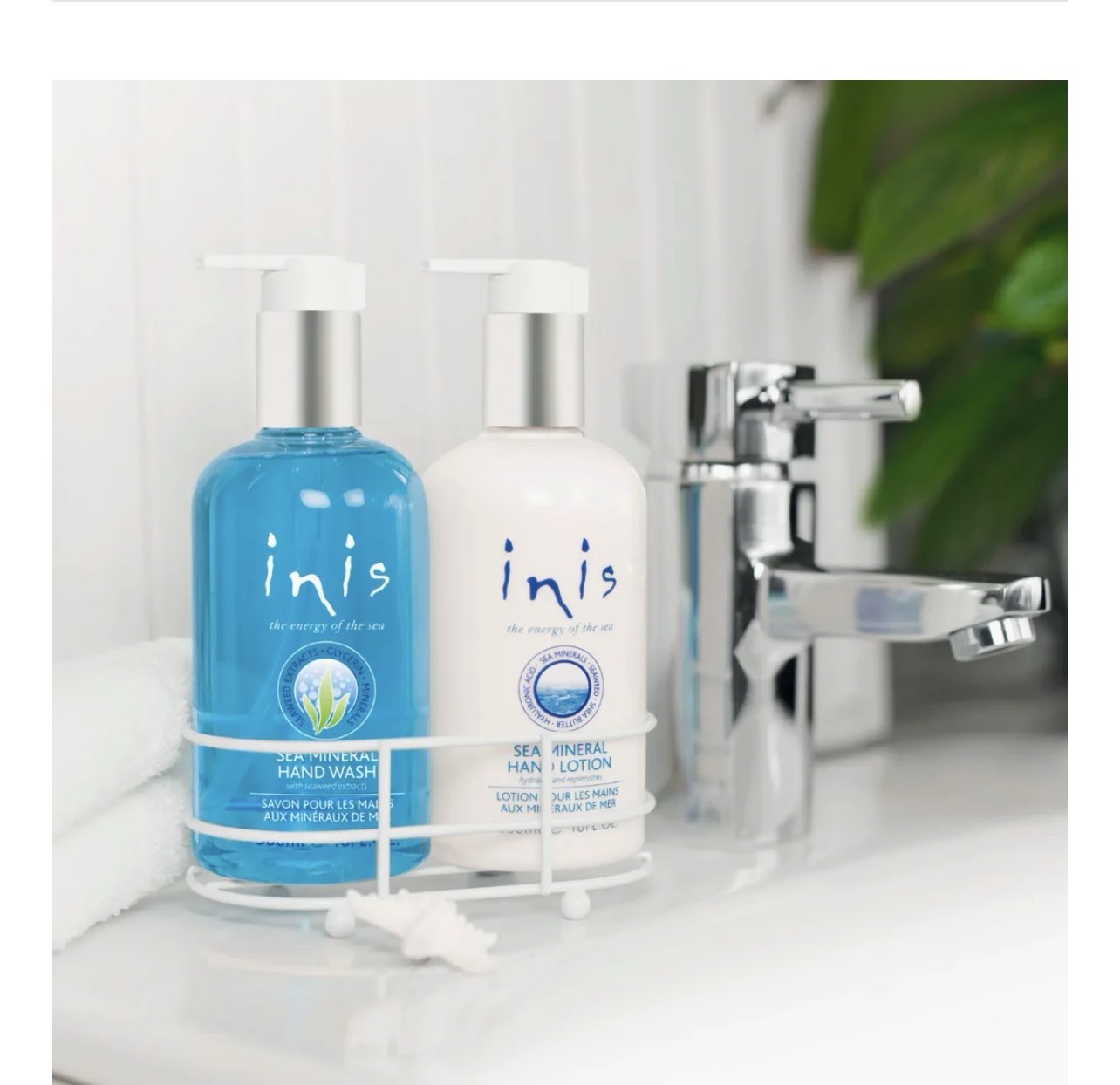 White metal caddy holding two 10 oz. bottles of Inis hand soap and hand lotion with coastal blue labels.
