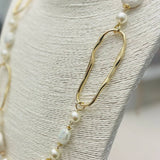 Long necklace with faux pearls and faceted stones draped on a display bust, showcasing layered textures