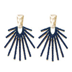 Navy statement drop earrings with a sunburst design, shown on a neutral background to highlight shine and shape