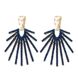 Navy statement drop earrings with a sunburst design, shown on a neutral background to highlight shine and shape