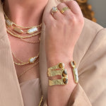 Gold cuff bracelet featuring tiger’s eye stones and a freshwater pearl accent.
