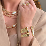 Gold cuff bracelet featuring tiger’s eye stones and a freshwater pearl accent.