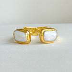 Gold open cuff bracelet featuring medium freshwater pearls on both ends.