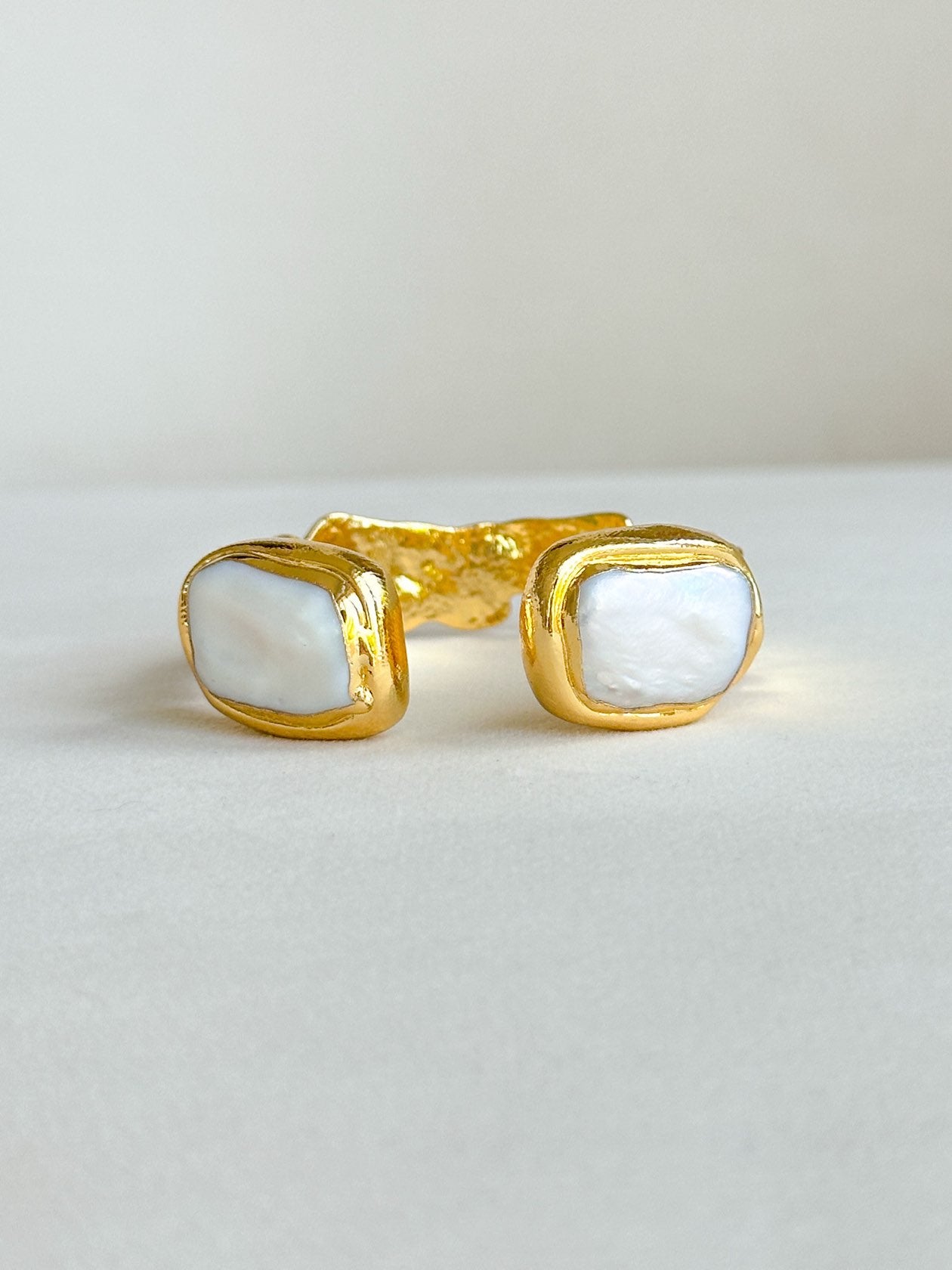 Gold open cuff bracelet featuring medium freshwater pearls on both ends.