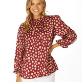 Garnet and gold animal print blouse with frill neckline, ruffle sleeves, and keyhole back closure