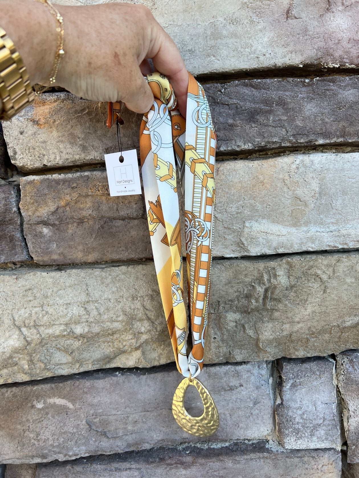 Cream, tan, and yellow scarf necklace with hammered gold open teardrop pendant, handmade by Hart Designs.