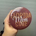 A garnet, gold, and white Florida State Mom pin attached to a neutral bag, perfect for FSU game day.