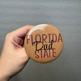 A garnet, gold, and black Florida State Dad pin attached to a neutral bag, perfect for FSU game day.