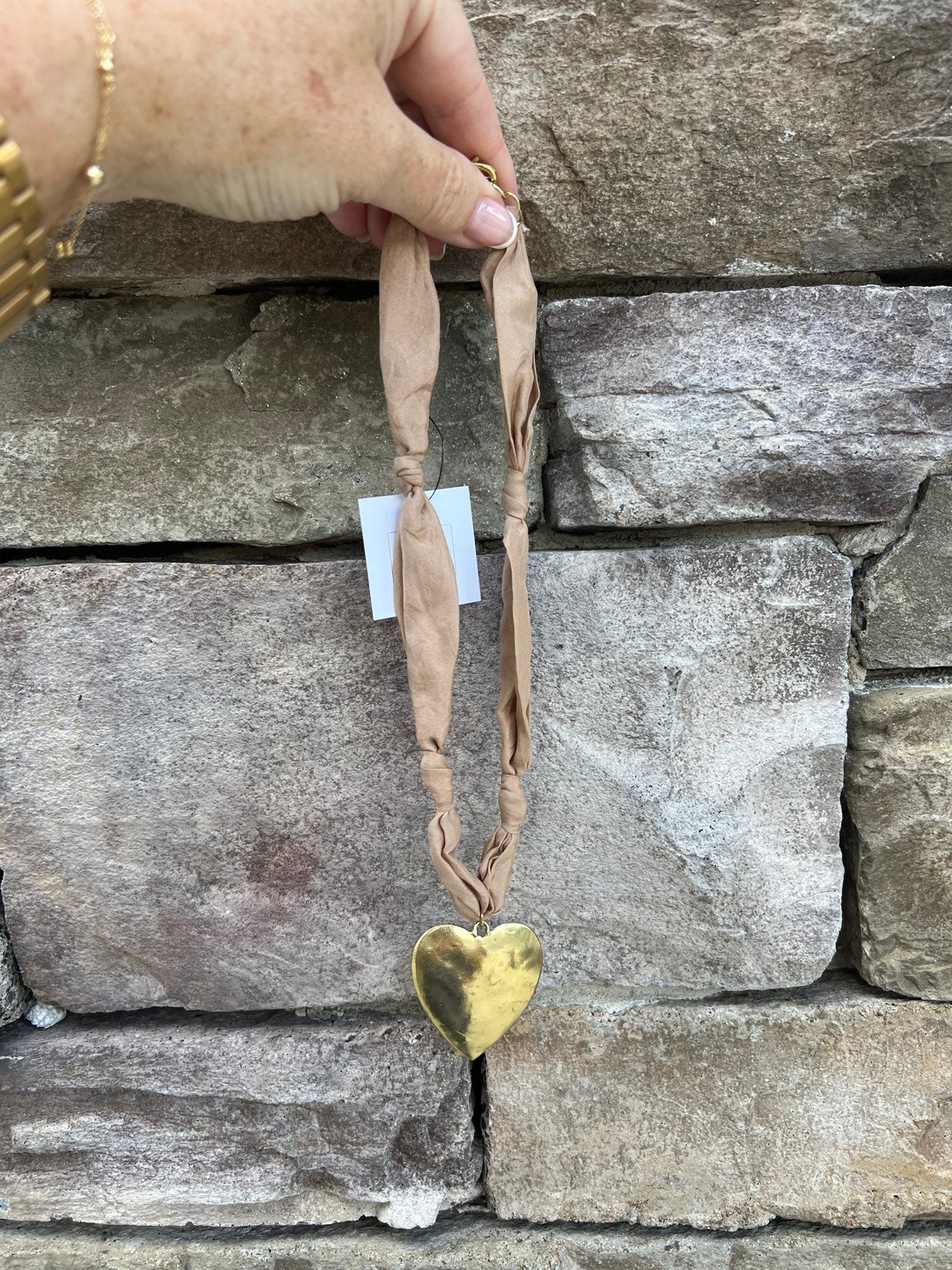 Tan scarf-style necklace with hammered gold heart pendant, handmade by Hart Designs.