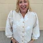 Oat velvet puff sleeve top with floral embroidery, gold buttons, and ruffle collar