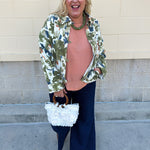 Painted Woodland Jacket featuring an olive, green, blue, and orange botanical print on a white background, a collared neckline, loop button closures, long sleeves, side pockets, and a cropped boxy silhouette.