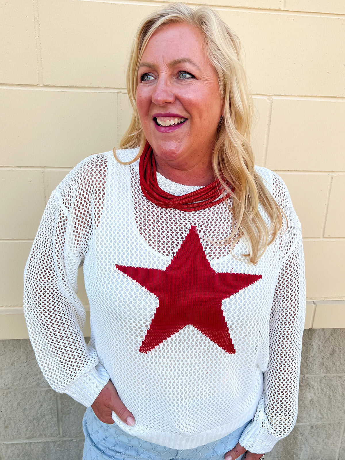 An oversized open-stitch knit sweater top featuring a bold star jacquard design and relaxed long sleeves.