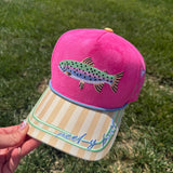 Pink faux suede and canvas snapback hat featuring an embroidered rainbow trout on the front, yellow striped brim with "Reel-y Busy" embroidery, periwinkle rope trim, fishing-themed side embroidery, and "Catch Ya Later" embroidered on the back.