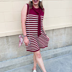 Garnet and white vertical striped sleeveless dress with round neckline, shoulder tie details, and knee-length silhouette.