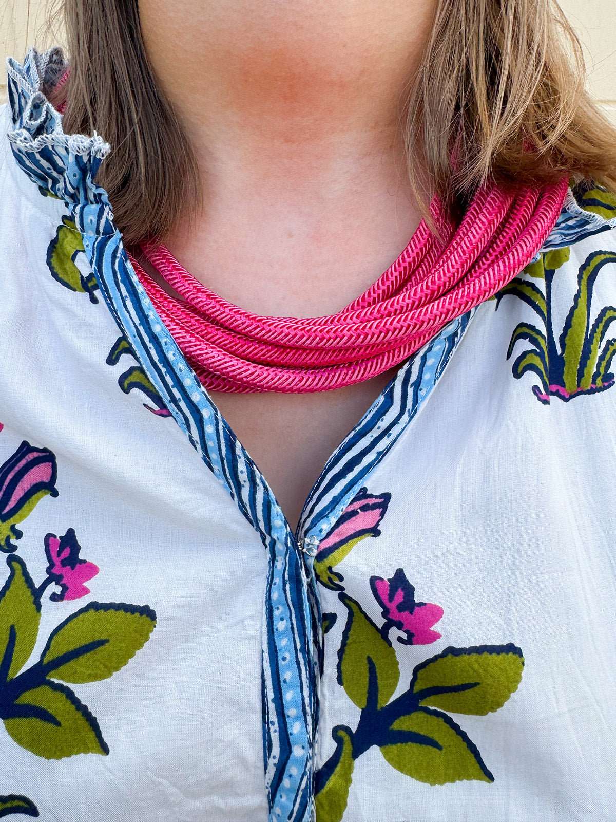 Berry-colored multi-strand cotton rope necklace with a ball-and-eye closure displayed as a bold, seasonal accessory