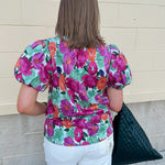 Vibrant raspberry floral blouse with ruffle-trimmed split neckline and short puff sleeves
