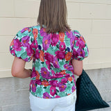 Vibrant raspberry floral blouse with ruffle-trimmed split neckline and short puff sleeves