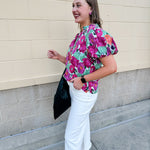 Vibrant raspberry floral blouse with ruffle-trimmed split neckline and short puff sleeves