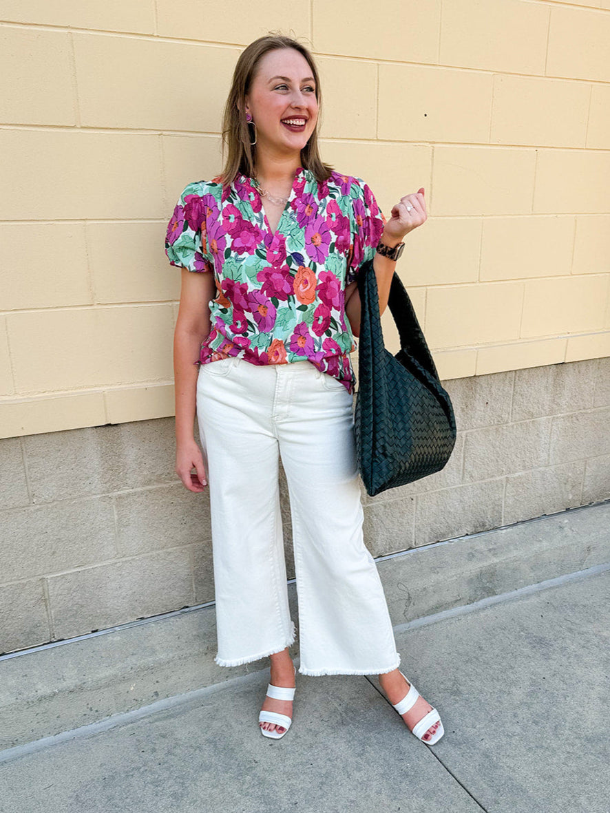 Vibrant raspberry floral blouse with ruffle-trimmed split neckline and short puff sleeves