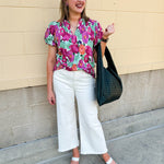 Vibrant raspberry floral blouse with ruffle-trimmed split neckline and short puff sleeves