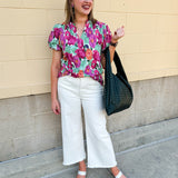 Vibrant raspberry floral blouse with ruffle-trimmed split neckline and short puff sleeves