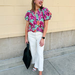 Vibrant raspberry floral blouse with ruffle-trimmed split neckline and short puff sleeves