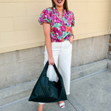 Vibrant raspberry floral blouse with ruffle-trimmed split neckline and short puff sleeves