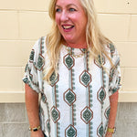 White linen blouse with green and brown boho-inspired pattern and elasticized sleeves